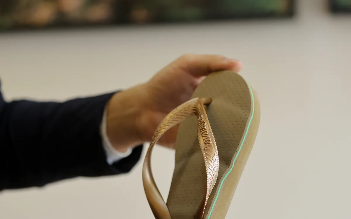 Chinelo com palmilha 3D personalizada, segurado nas mãos